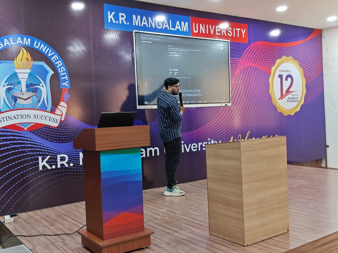 A mentor with a microphone demonstrating the OpenAI platform on a large screen